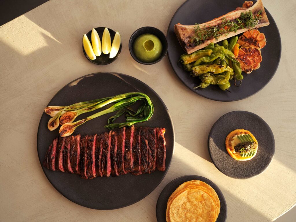 A table adorned with plates of delicious food and a glass of wine, creating an inviting and appetizing scene.