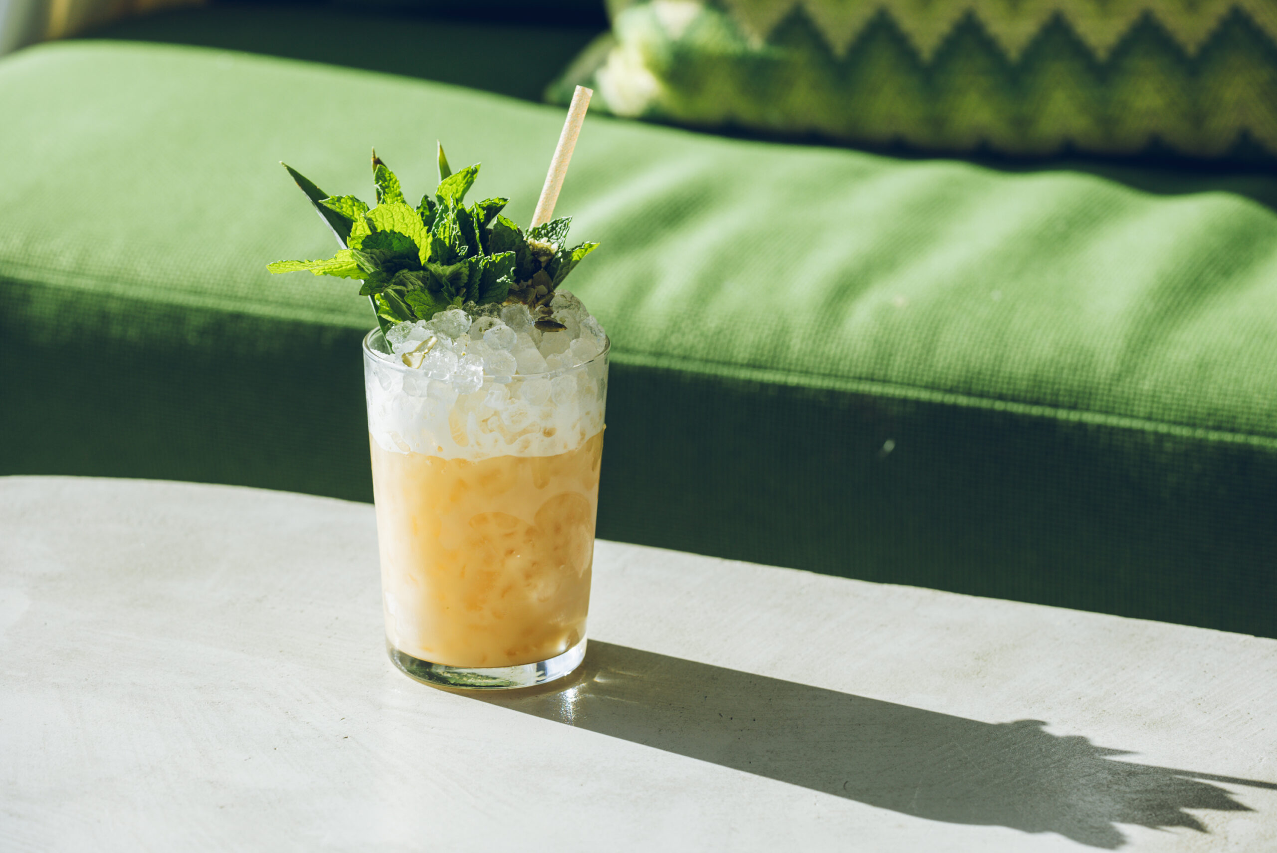 A refreshing beverage with ice and a straw placed on a table, ready to be enjoyed.